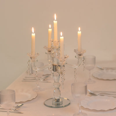 Elegant crystal candelabra with five lit candles on a dining table.