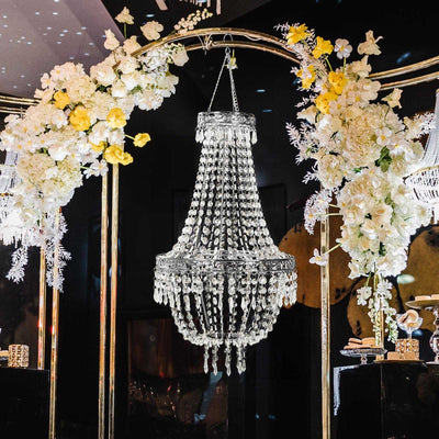 Elegant crystal chandelier adorned with flowers in a decorative setting.
