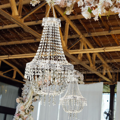 Elegant crystal chandeliers hanging in a beautifully decorated venue.