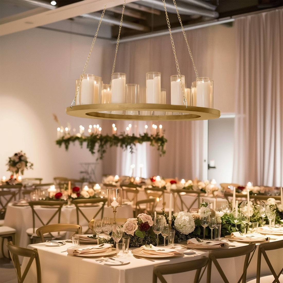 Elegant chandelier with candles above beautifully arranged dining tables in a stylish venue.