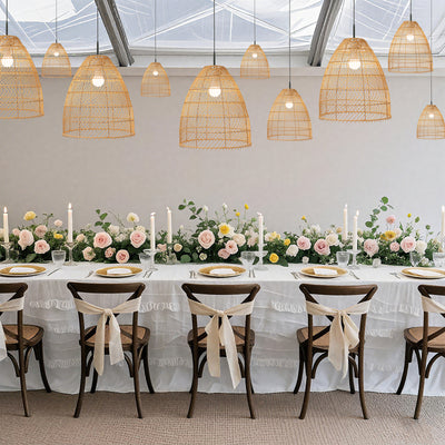 Elegant dining table set with floral centerpieces and decorative lighting.