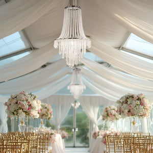 Elegant chandelier adorned with crystals in a beautifully decorated wedding venue.