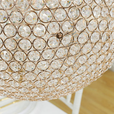 Elegant crystal chandelier with a gold frame, showcasing intricate detailing.