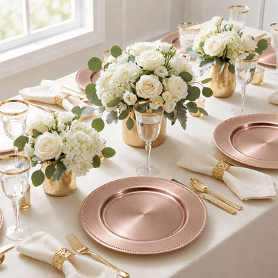 Elegant rose gold wedding table setting with white floral centerpieces