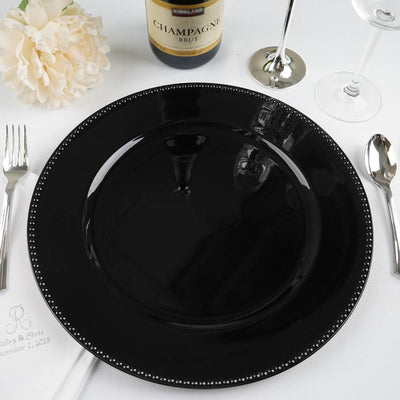 Elegant black dinner plate with beaded edge on a table setting.