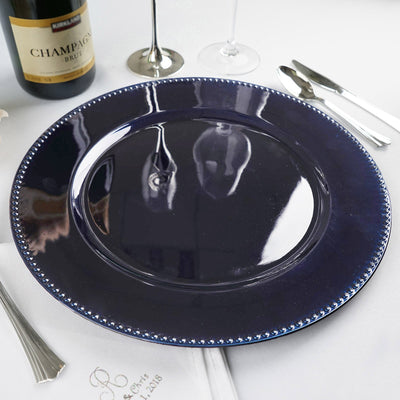 Navy blue decorative charger plate with beaded rim on a dining table
