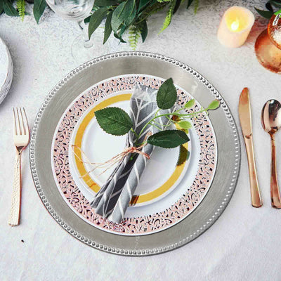 Elegant table setting with decorative plates, napkin, and greenery.
