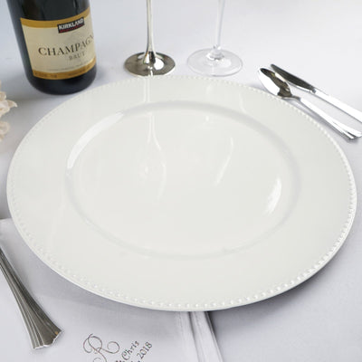 Elegant white dinner plate with beaded rim on plain backdrop