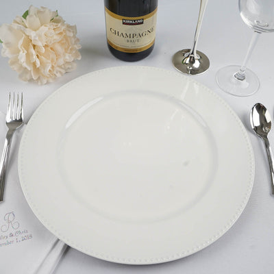 Elegant white dinner plate with decorative edge on a dining table setting.