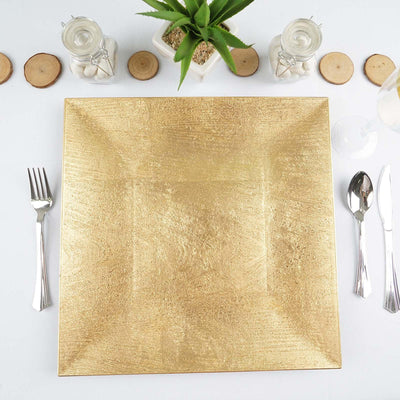Gold textured serving platter with silver cutlery and a potted plant.