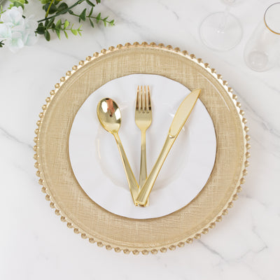 Elegant gold cutlery on a textured plate atop a decorative charger.
