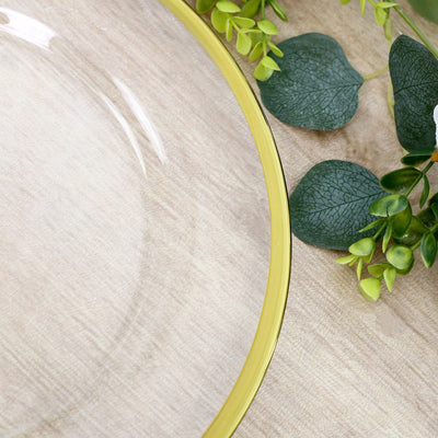 Glass bowl with green leaves on a light wood background