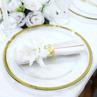 Elegant gold-rimmed charger plate with white napkin and floral decor