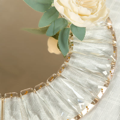 Elegant round mirror with crystal accents and a decorative flower arrangement.