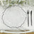 Clear glass plate with black rim on a textured table setting.