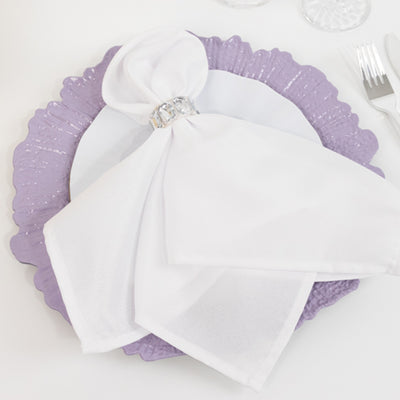 Elegant white napkin on a decorative purple plate setting.