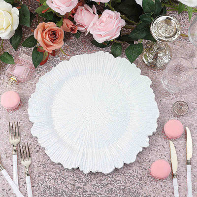 Elegant white plate surrounded by pink macarons and flowers on a textured table setting.