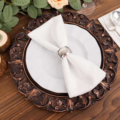 Elegant decorative plate with a white napkin and silver napkin ring on a wooden table.