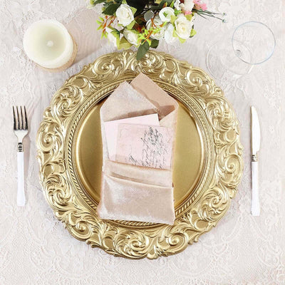 Elegant gold charger plate with a pink envelope and floral decor on a lace tablecloth.