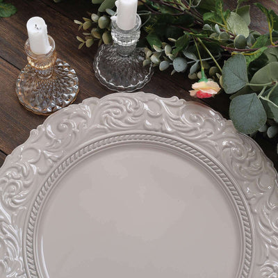 Elegant decorative plate with intricate design, surrounded by candles and greenery.