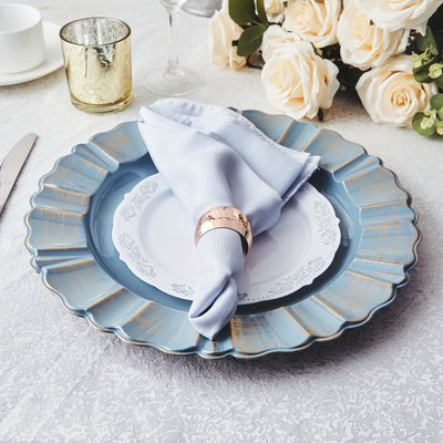 Elegant blue plate with white dish, napkin, and rose bouquet centerpiece.
