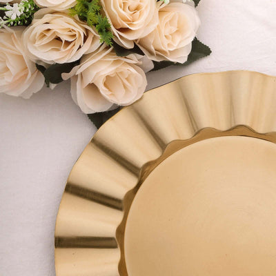 Gold fluted charger plate with faux flowers on a soft white background.