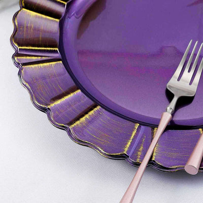 Purple scalloped plate with a fork and knife on a white tablecloth.