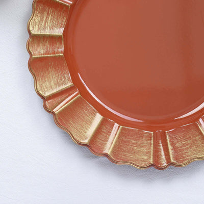 Terracotta plate with gold rim, scalloped edge design.