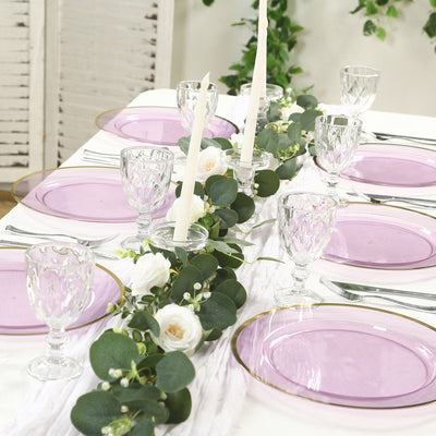 Elegant dining table setup with purple plates and floral centerpiece.