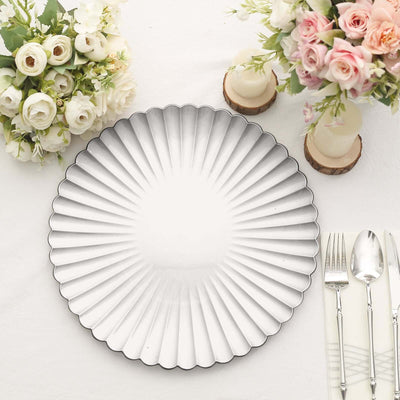 Decorative silver charger plate on a dining table with floral arrangements.