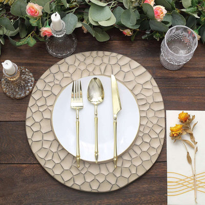 Elegant gold cutlery set on textured placemat with white plate and decorative elements.