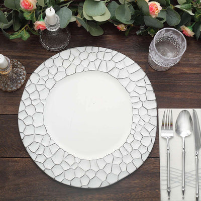 Elegant white plate with geometric border, styled with cutlery and glassware.