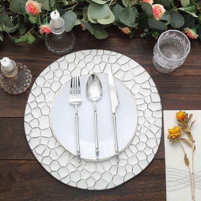 Elegant dining set with plate, cutlery, and glassware on a stylish table arrangement.