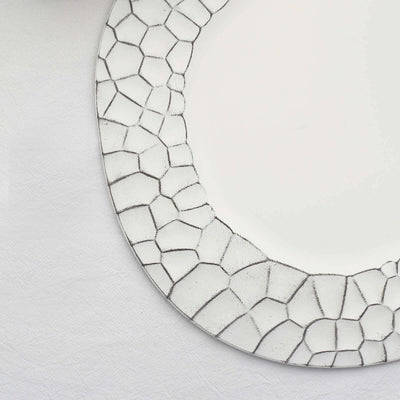 Decorative round plate with a textured silver edge on a plain background.