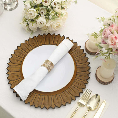 Elegant gold sunburst charger plate with white napkin and floral centerpiece.