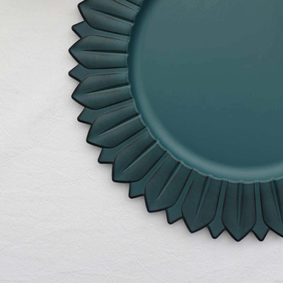 Teal decorative plate with a petal-like rim design.