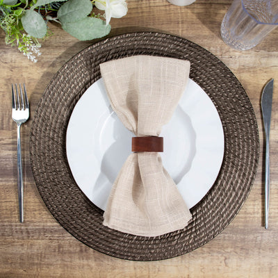 Elegant table setting with a beige napkin and brown placemat.