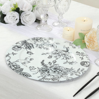Floral decorative plate on a dining table with candles and flowers.