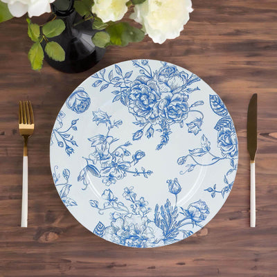 Blue floral design dinner plate on wooden table with gold cutlery.