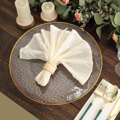 Elegant cream napkin elegantly arranged on a textured glass plate with table setting.