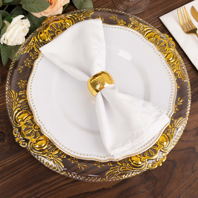 Elegant white plate with gold-accented napkin ring on ornate charger.