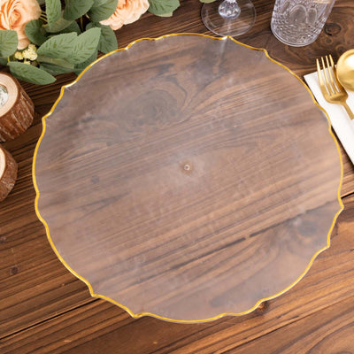 Clear acrylic charger plate with gold trim on a wooden table.
