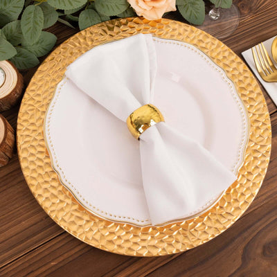 Elegant gold and white dinner plate with a napkin on a textured charger.