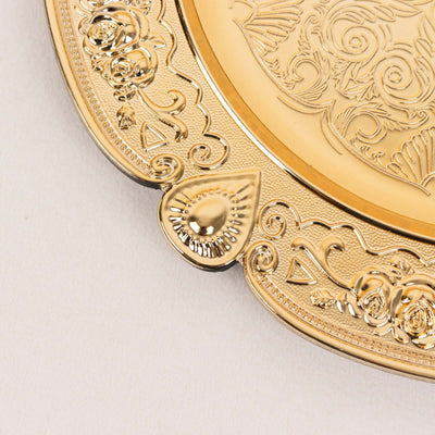 Elegant gold decorative plate with intricate floral designs and detailed edges.