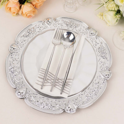 Elegant silver decorative charger plate with cutlery and napkin arrangement.