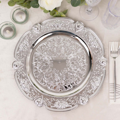Ornate silver serving platter with intricate floral design on a table setting.