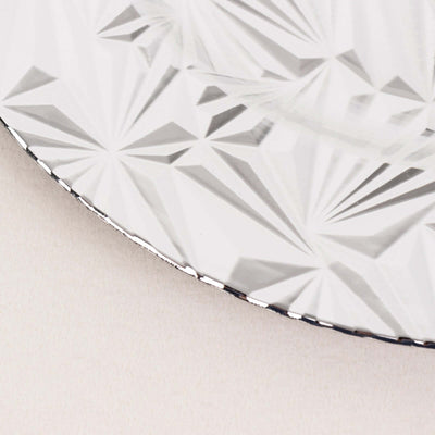 Decorative silver plate with a textured geometric pattern.