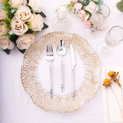 Elegant dinner plate with gold trim, fork, knife, and spoon, set with flowers.