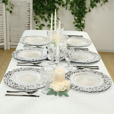 Elegant dining table setting with decorative plates, glasses, and candles.