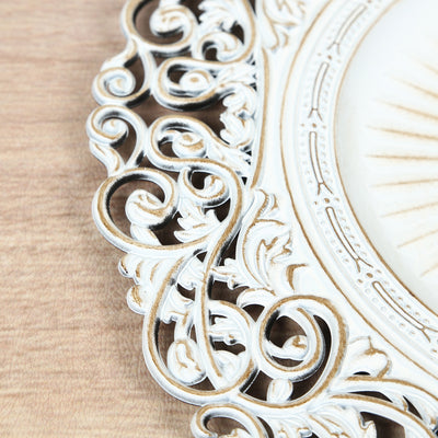Ornate white decorative frame detail with intricate scrollwork.